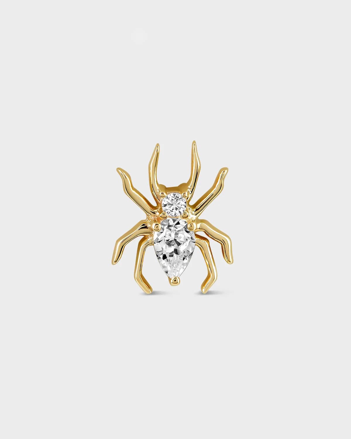 Gold spider-shaped earring with clear gemstones on a light gray background