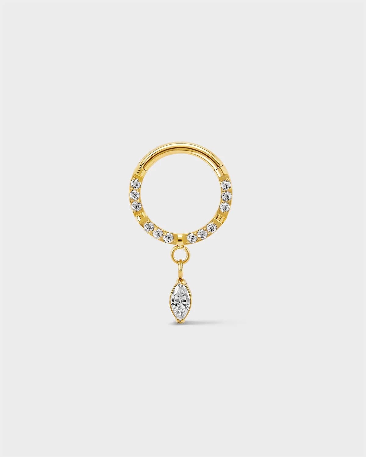 Semi pave gold titanium daith septum ring with a marquise dangle charm sat on a light gray background.