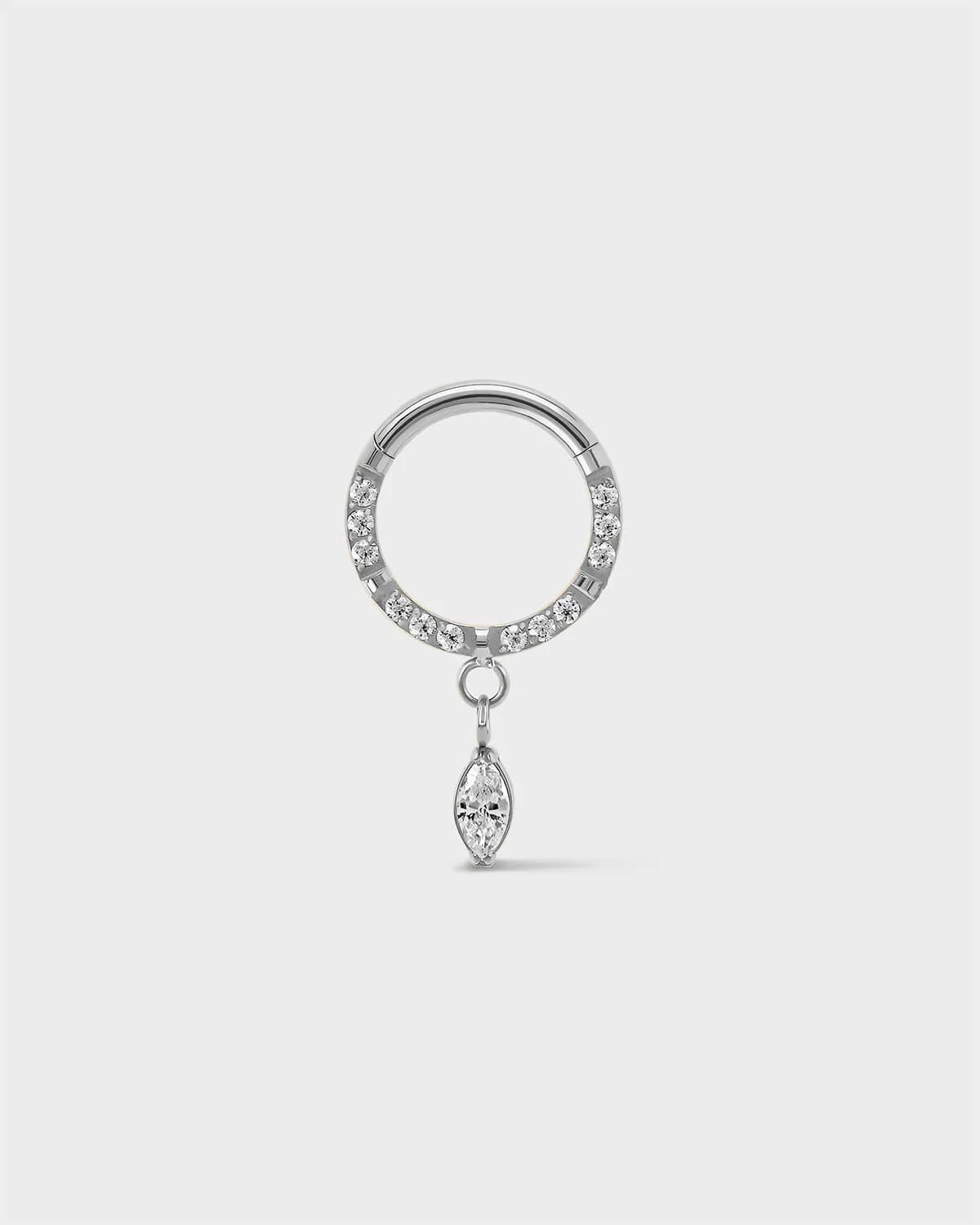 Semi pave polished silver titanium daith septum ring with a marquise dangle charm sat on a light gray background.
