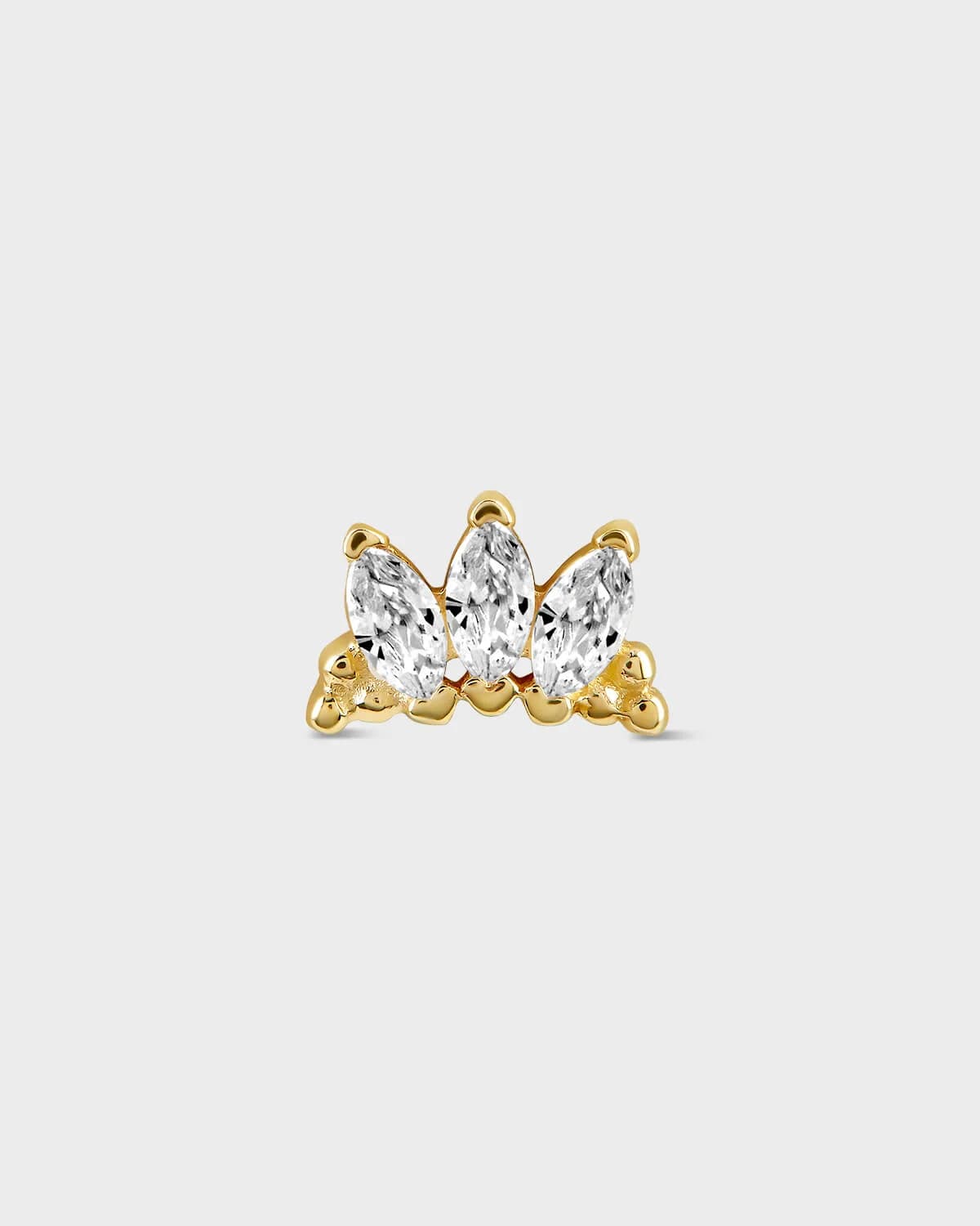 Gold earring with three clear gemstones on a light gray background