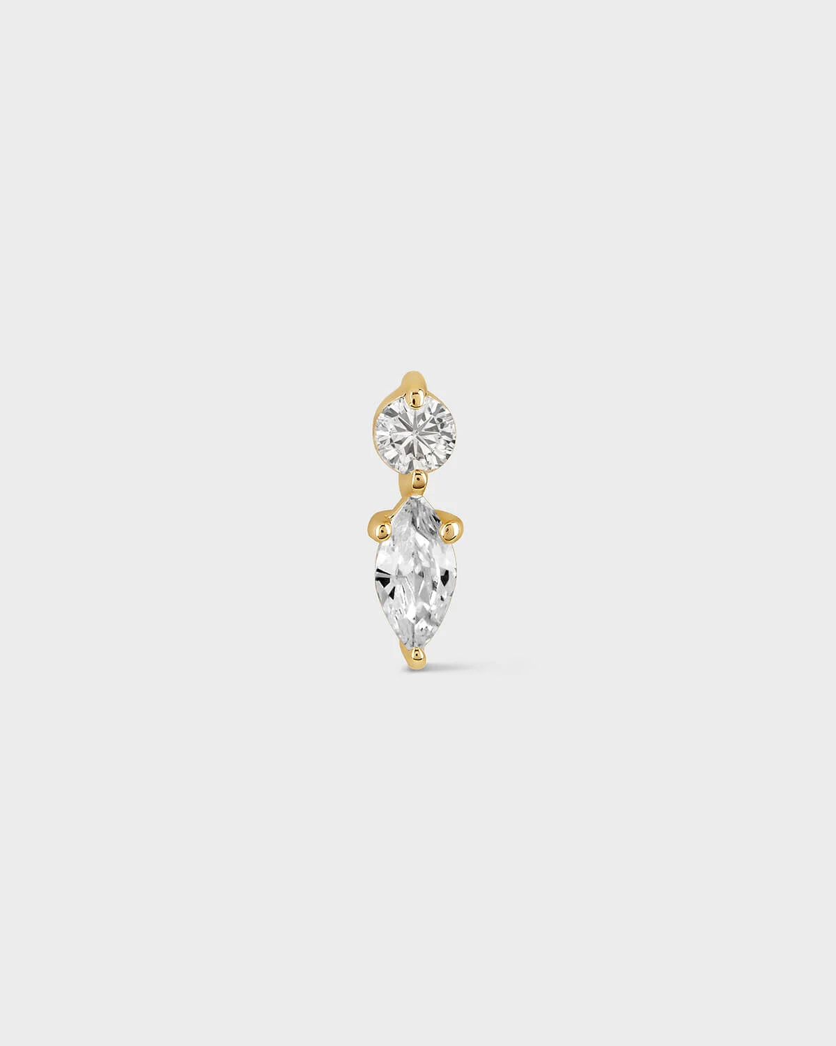 Gold earring on a light gray background