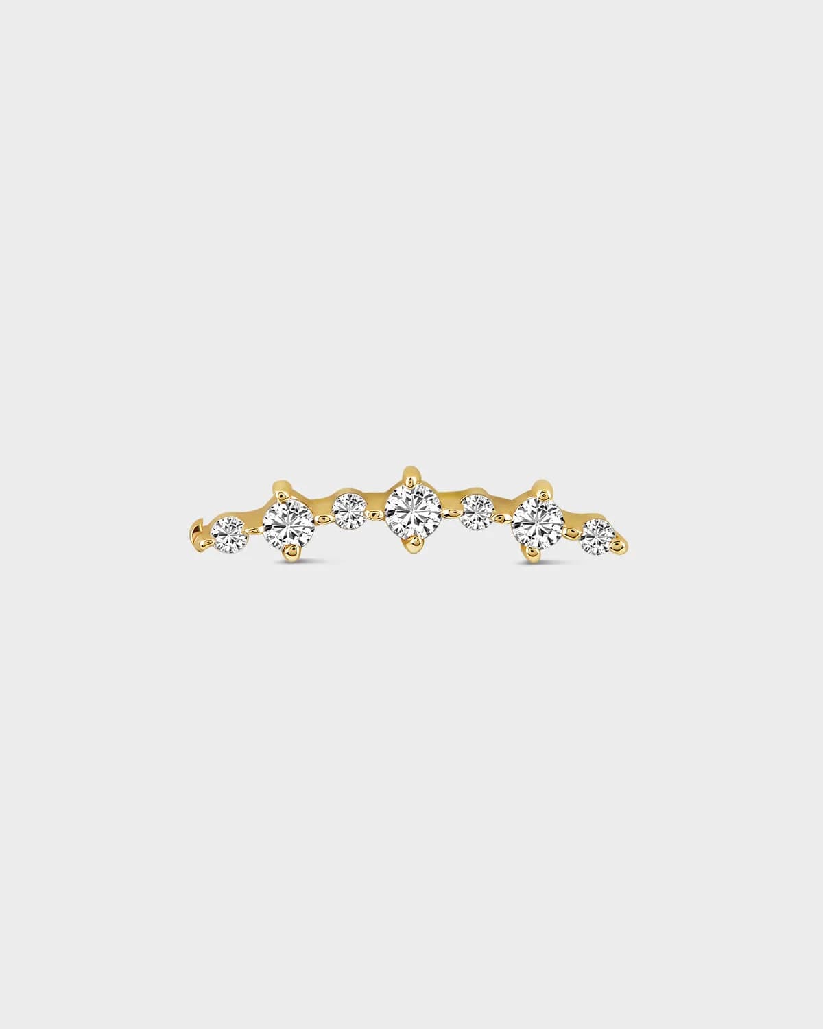 Gold earring with diamonds on a light gray background