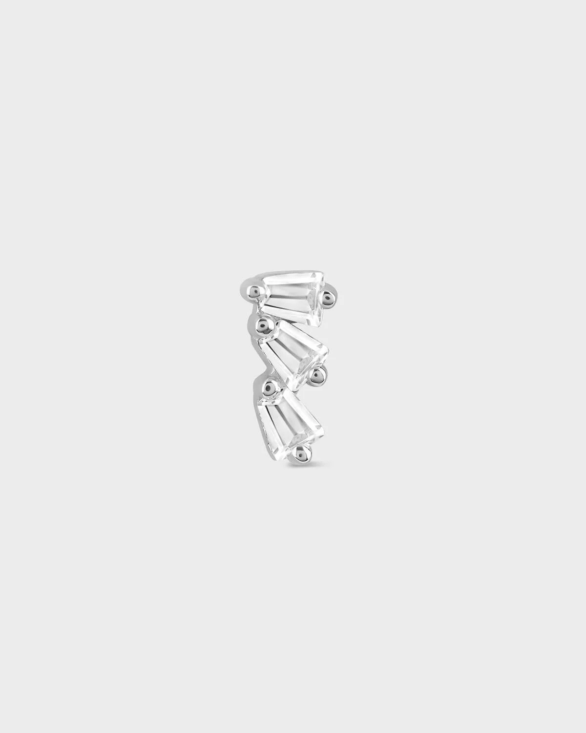 Silver earring on a light gray background