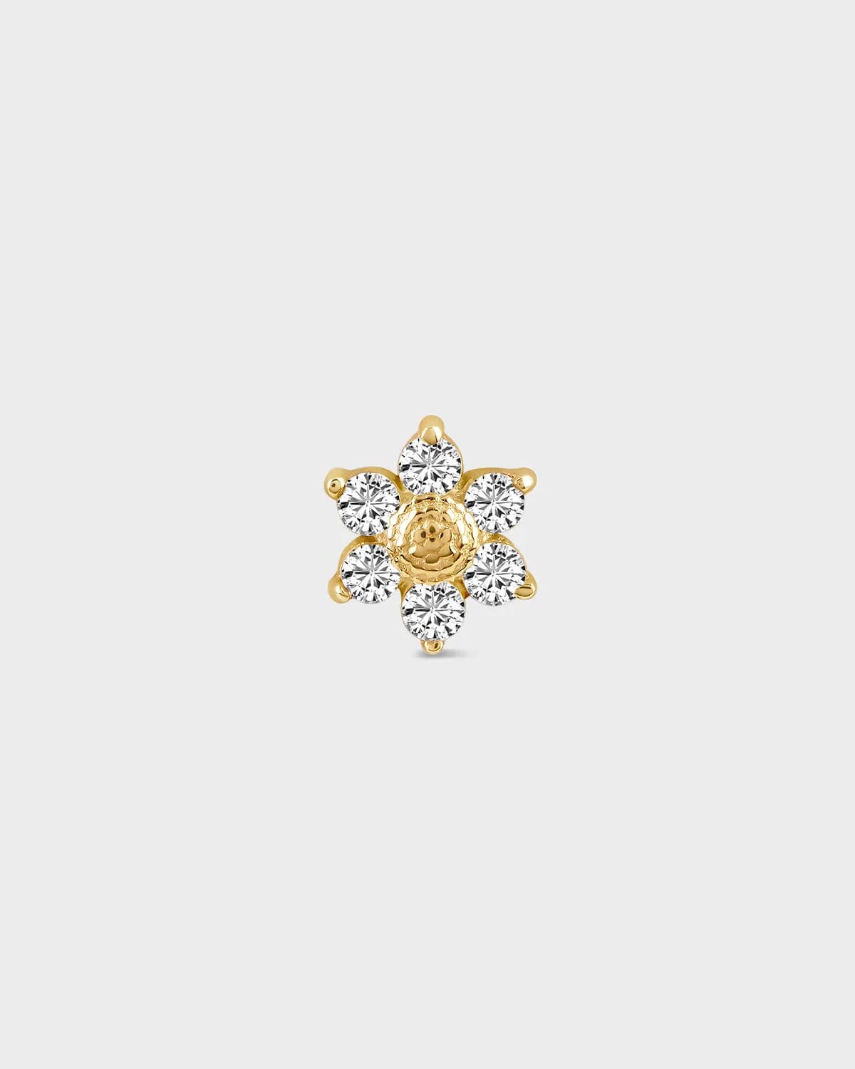 Gold and diamond earring on a light gray background