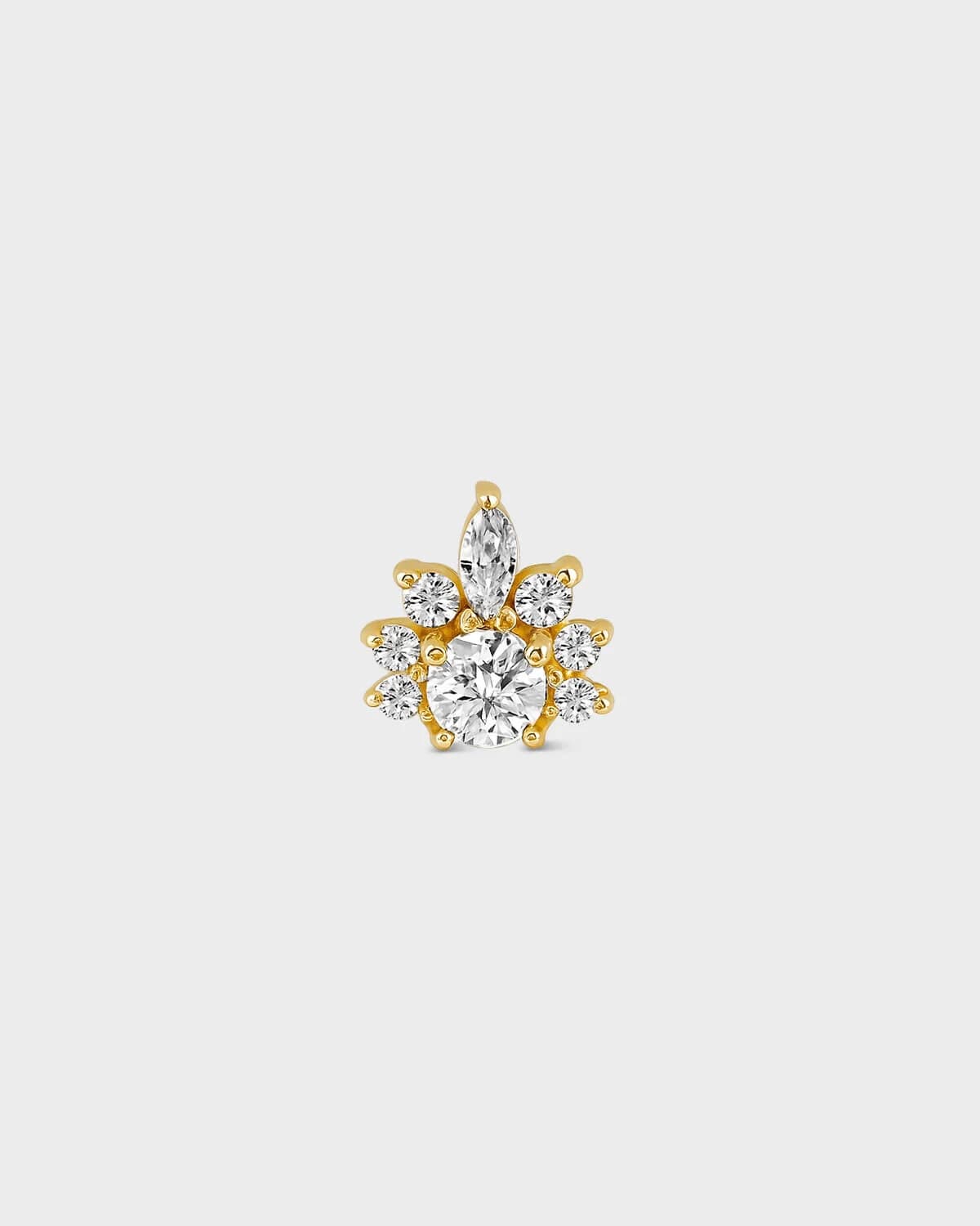 Gold earring with clear gemstones on a light gray background