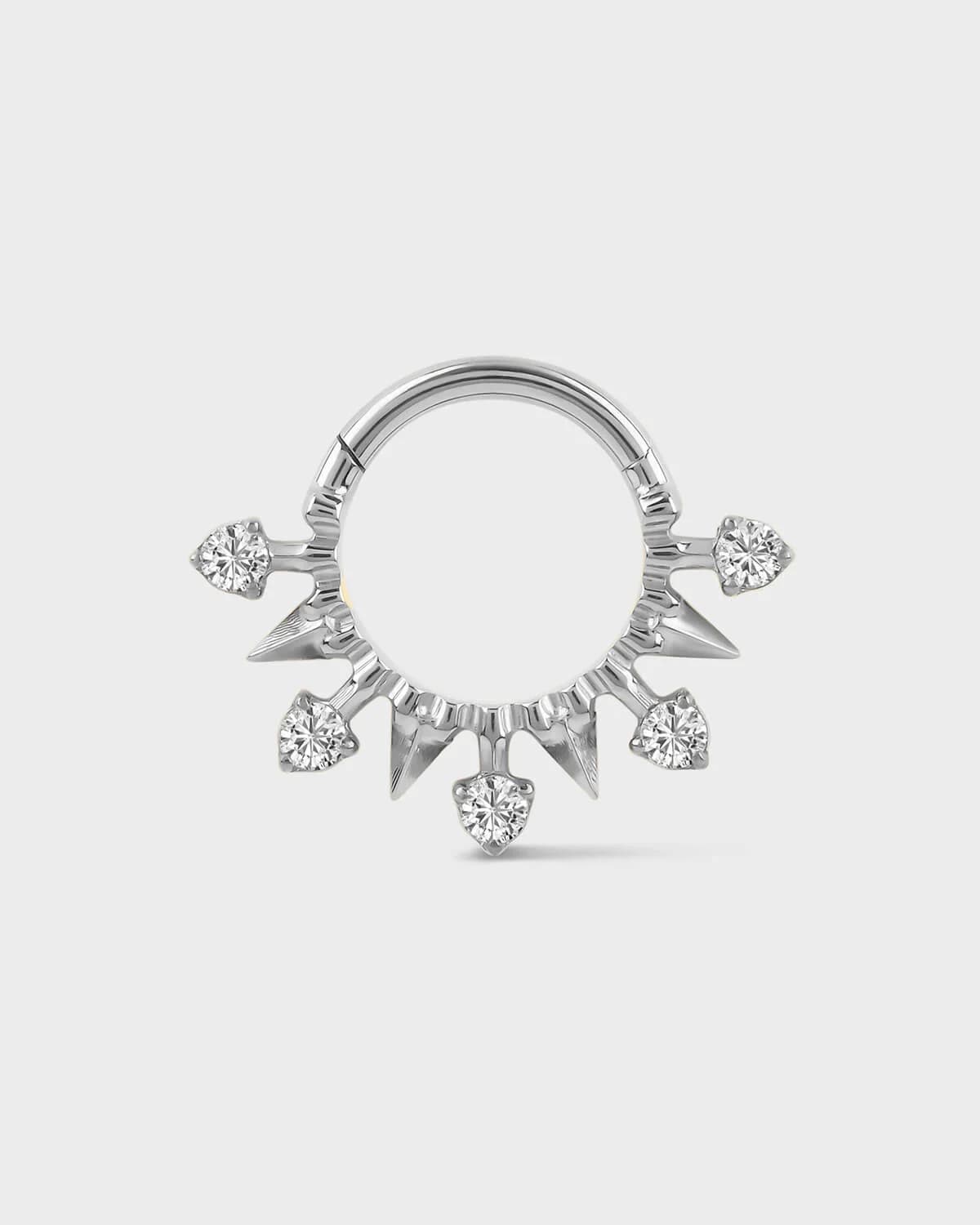 Polished silver titanium daith or septum ring with alternating spikes and solitaires on a light gray background.