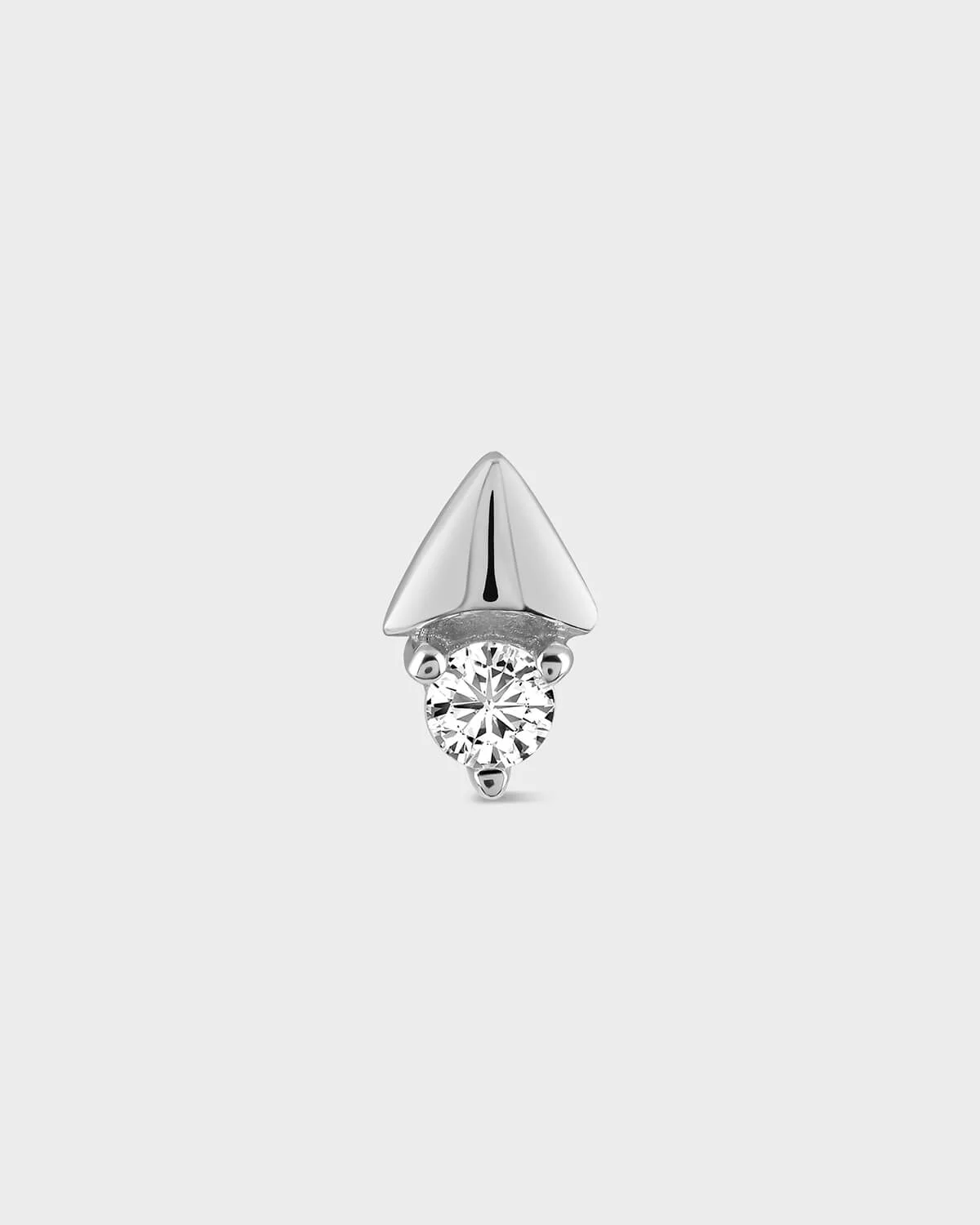 Silver earring with a clear gemstone on a light gray background