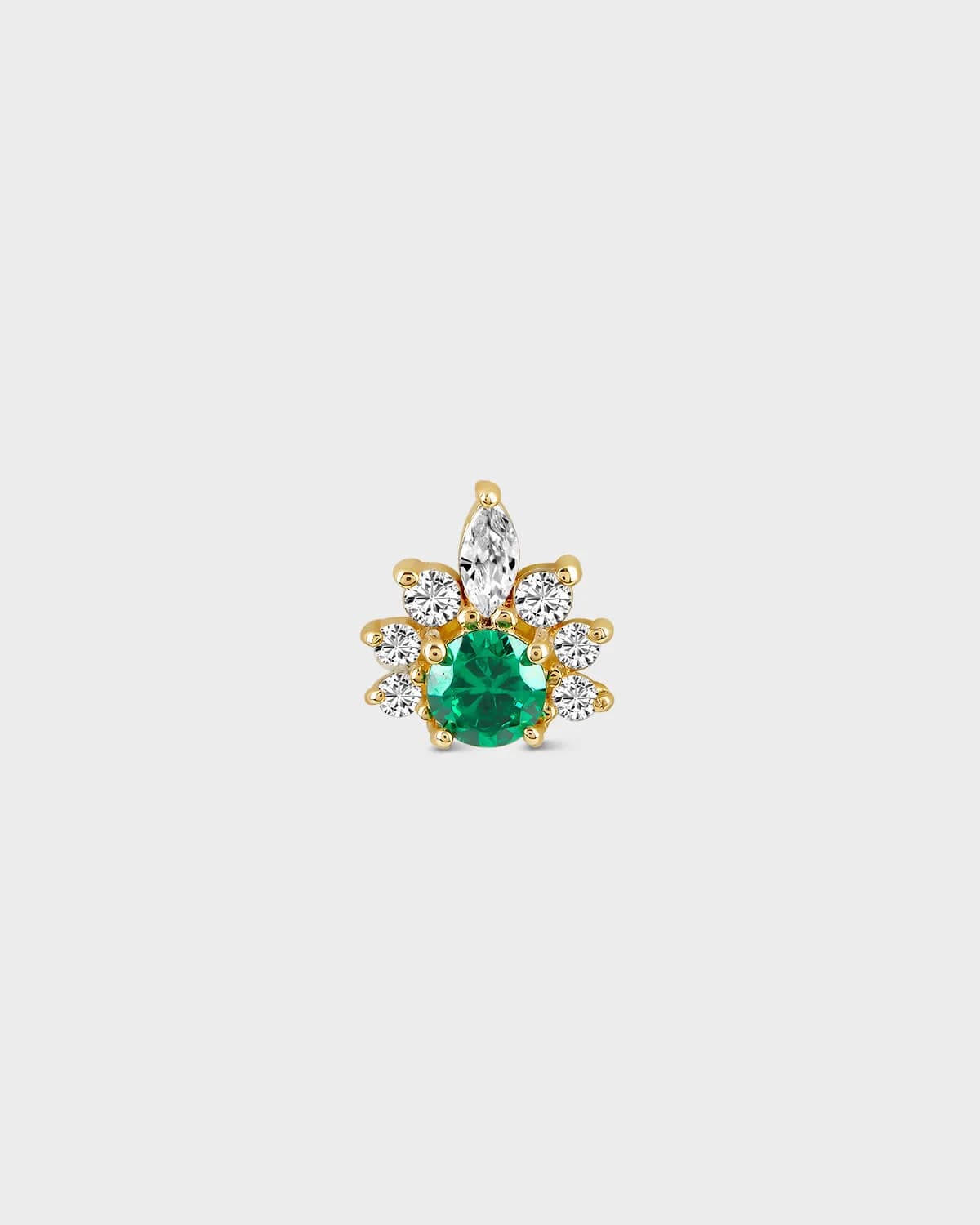 Gold earring with a green gemstone on a light gray background