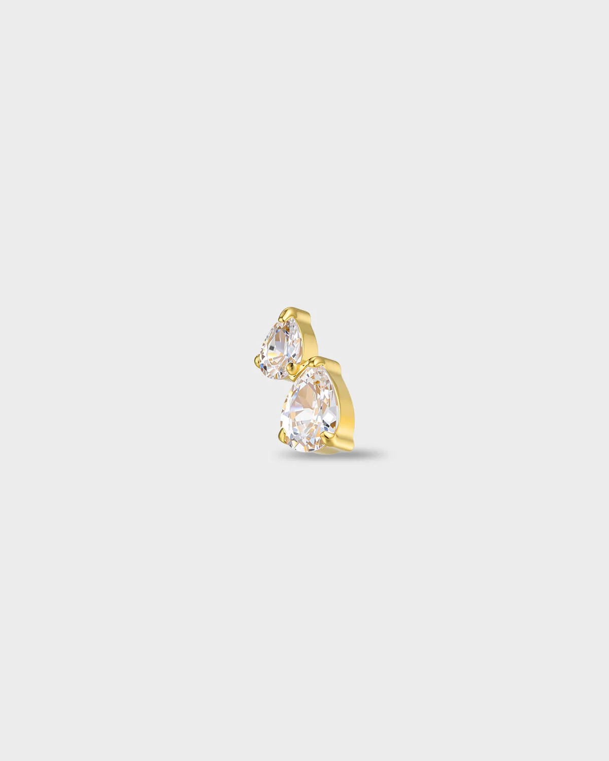 Gold titanium earring with two pear-cut clear stones set in a stacked arrangement, on a light gray background.