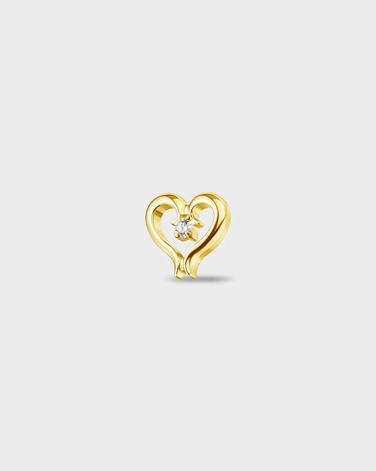 Gold titanium earring with an open heart shape and a single round-cut clear stone set at the centre, on a light gray background.