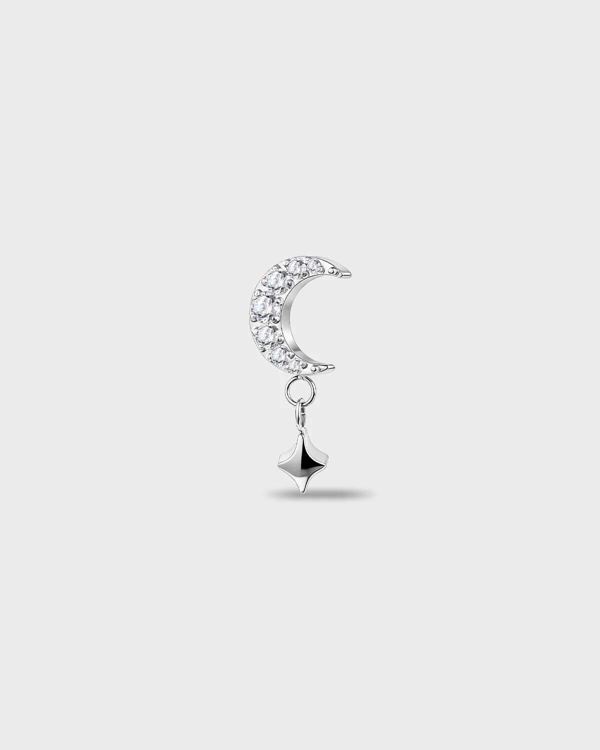Polished silver titanium earring with a crescent shape set with clear round stones and a short dangle star detail on a light gray background.