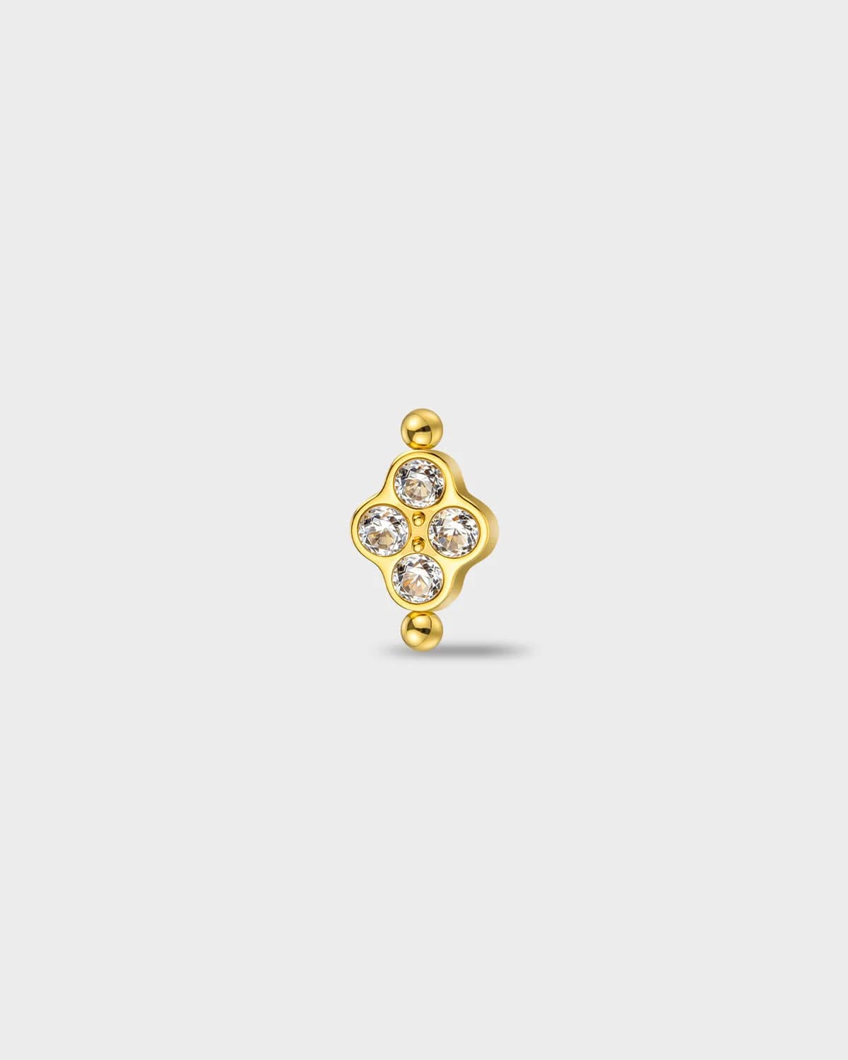Gold titanium earring with four round-cut clear stones set in a compact cluster, finished with polished bead details at the top and bottom, on a light gray background.