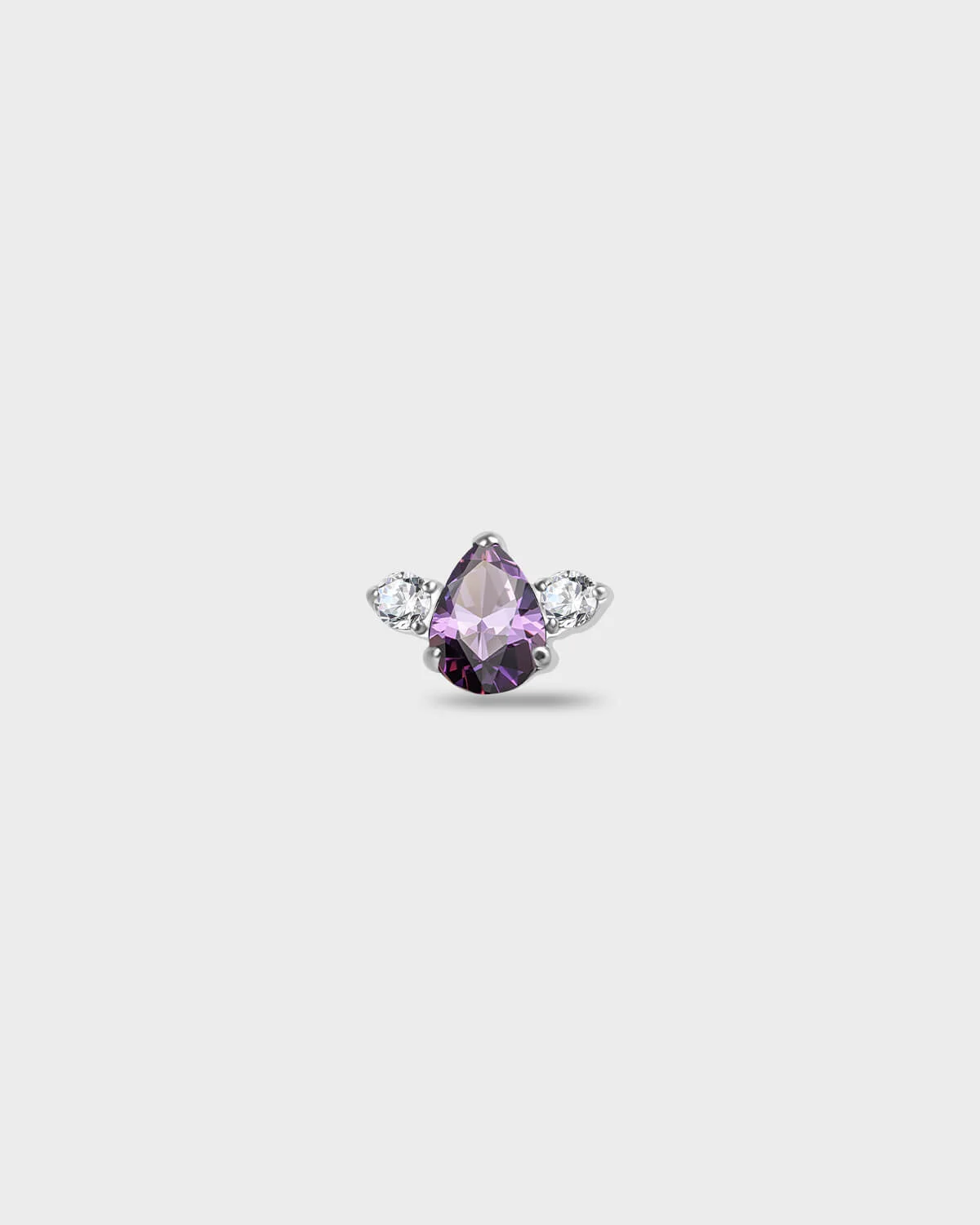 Polished titanium earring with a pear-cut purple stone set between two round-cut clear stones on a light gray background.