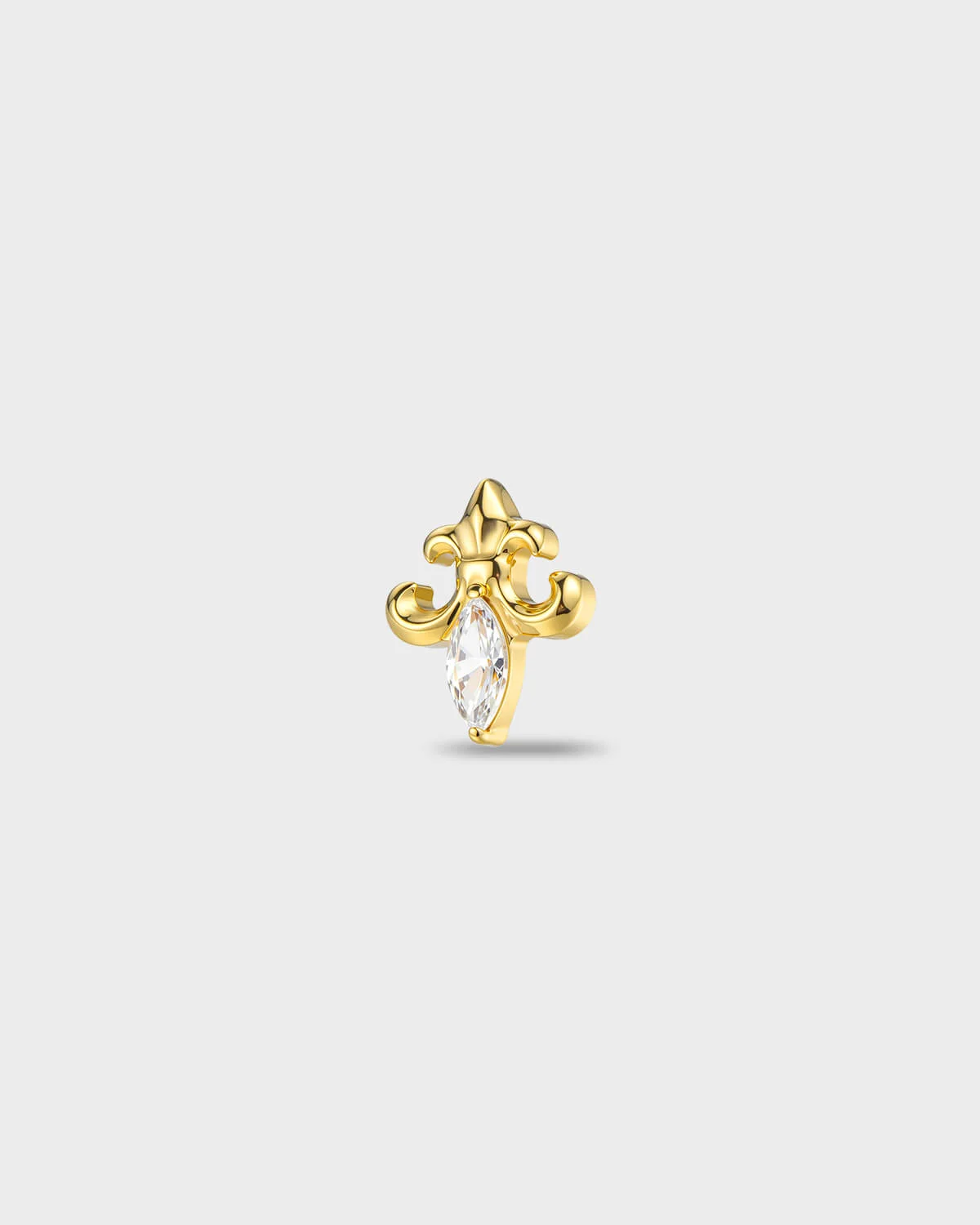 Gold titanium earring with a sculpted fleur-style shape and a marquise-cut clear stone set at the centre, on a light gray background.