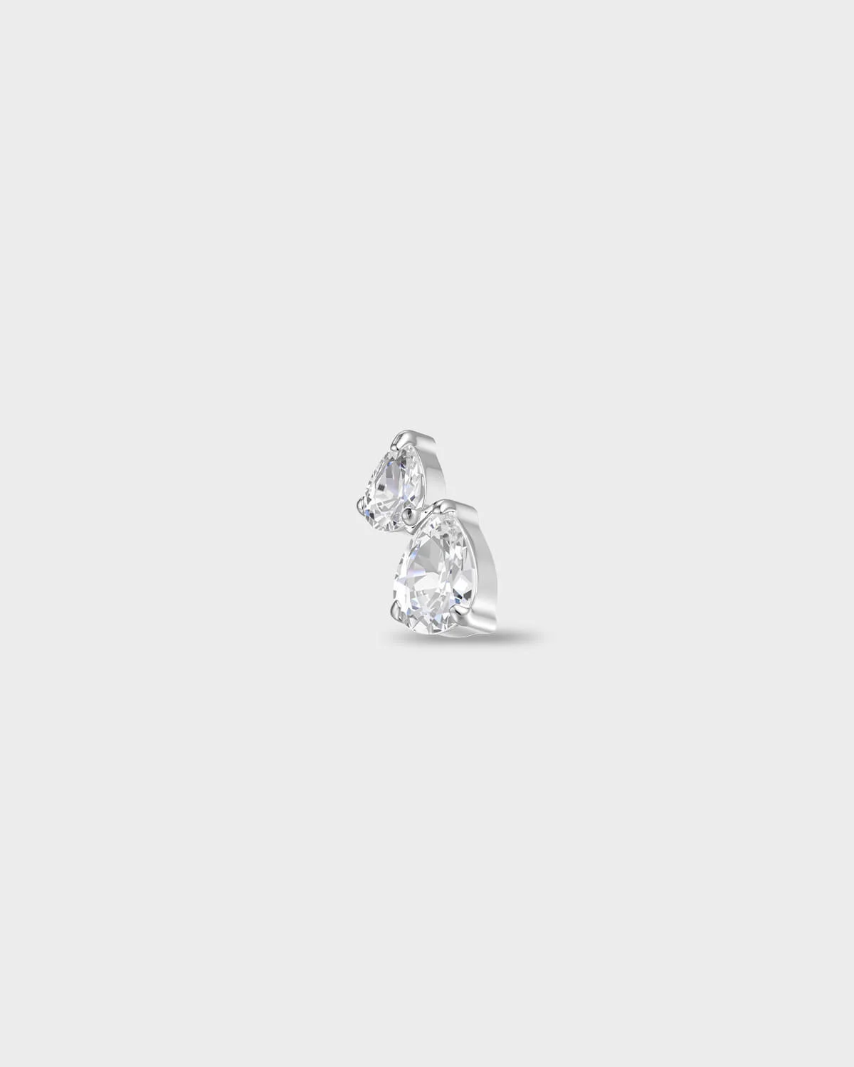 Polished titanium earring with two pear-cut clear stones set in a stacked arrangement, on a light gray background.